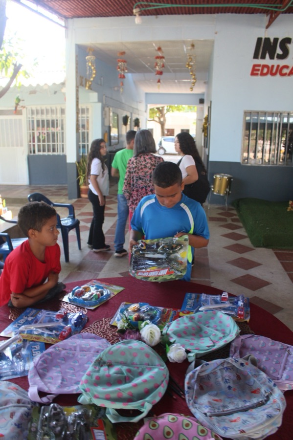 Backpacks and gifts set out on a table for students